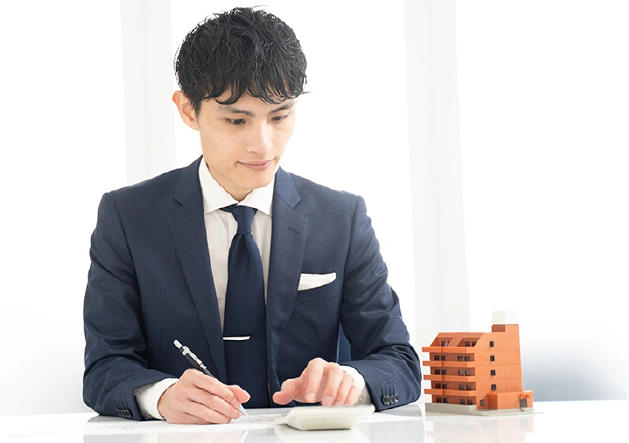 不動産の査定額を計算する男性の写真