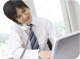 電話対応でPC操作をする男性